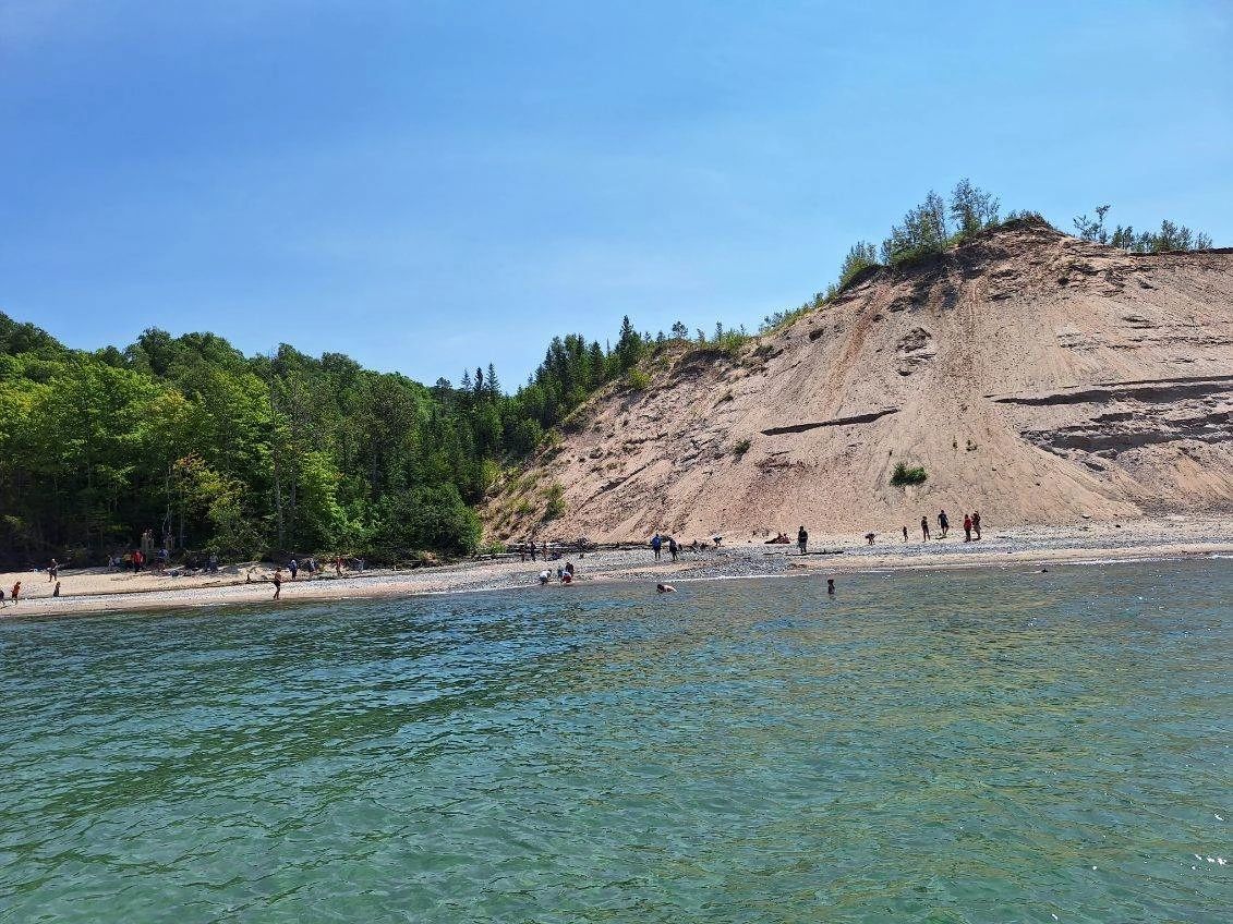 Clear turquoise Lake Superior water below a tall sand bank near Grand Marais